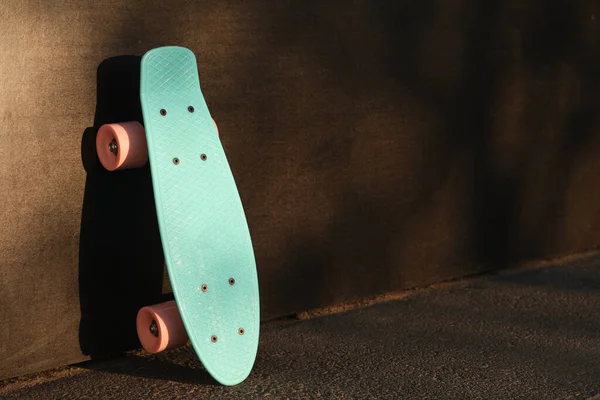 Modern Light Blue Skateboard Pink Wheels Black Wall Outdoors Space — Stock Photo, Image