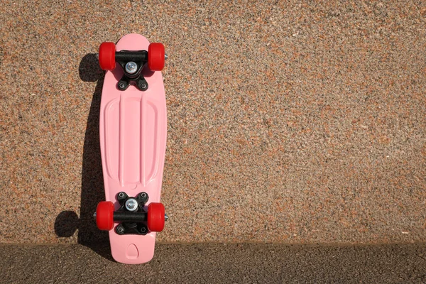 Roze Skateboard Met Rode Wielen Buurt Van Muur Buiten Ruimte — Stockfoto