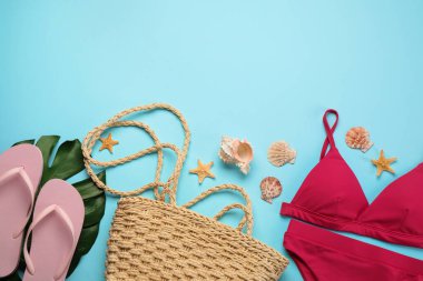 Turkuaz arka planda plaj aksesuarları olan şık bir çanta. Metin için boşluk
