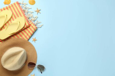 Açık mavi arkaplan üzerinde farklı plaj nesneleri ile düz kompozisyon, metin için boşluk