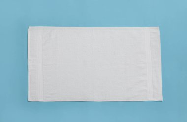 Açık mavi arka planda beyaz plaj havlusu, üst manzara