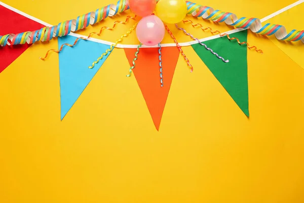 Bunting Met Kleurrijke Driehoekige Vlaggen Andere Feestelijke Decor Gele Achtergrond — Stockfoto