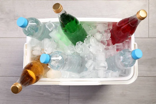 Plastic Koelbox Gevuld Met Ijsblokjes Verfrissende Drankjes Houten Vloer Bovenaanzicht — Stockfoto