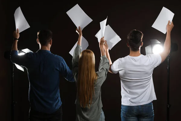 Professional actors reading their scripts during rehearsal in theatre