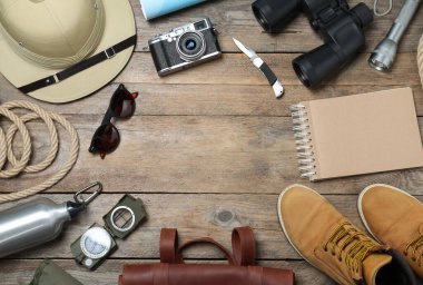Ahşap zemin üzerinde farklı safari aksesuarları ile düz kompozisyon, metin için boşluk
