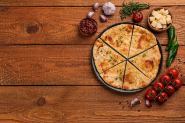 Tahta masada peynir, sos ve sebzeli nefis khachapuri. Metin için boşluk