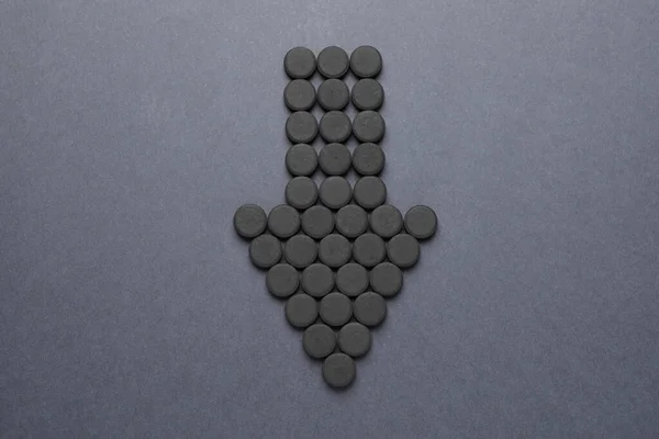 灰色の背景に活性化炭薬で作られた矢印 フラットレイアウト 強壮剤 — ストック写真