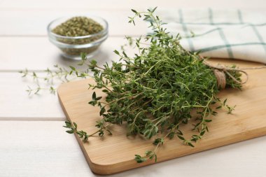 Beyaz ahşap masadaki aromatik kekik sürüsü, yakın plan.