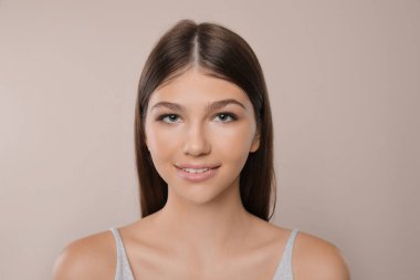 Aydınlık arka planda güzel bir kızın portresi. Güzel bir yüz, pürüzsüz bir ten.