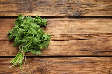 Ahşap masada taze aromatik kişniş var. Metin için boşluk