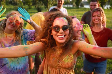 Açık havada renkli pudra boyalarıyla kaplanmış mutlu arkadaşlar. Holi festivali kutlaması