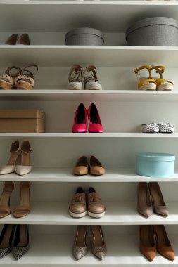 Farklı tarz kadın ayakkabıları olan depo rafı.