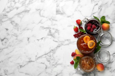 Farklı reçelli kavanozlar ve beyaz mermer masada taze meyveler, düz konum. Metin için boşluk