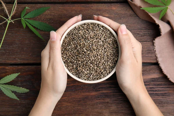 Woman Holding Bowl Hemp Seeds Wooden Table Top View — Stock Photo, Image