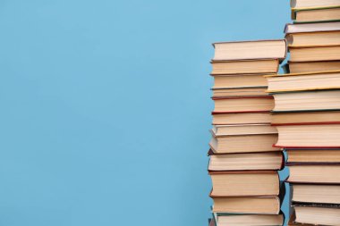 Turkuaz arka plan üzerine bir sürü ciltli kitap, metin için boşluk. Kütüphane materyali