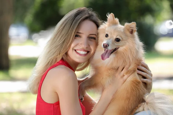 若いです女性とともに彼女の可愛いです犬で公園上の晴れた日 — ストック写真