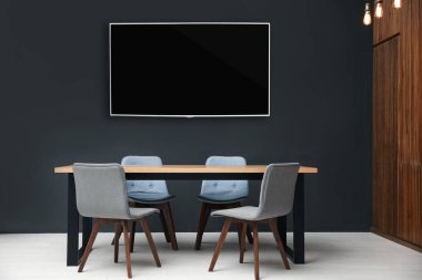 Modern geniş ekran televizyon siyah duvarda şık mobilyalarla 