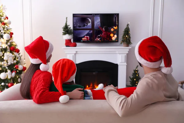 家族はクリスマスのために装飾された部屋でテレビでお祝い映画を見て バックビュー — ストック写真
