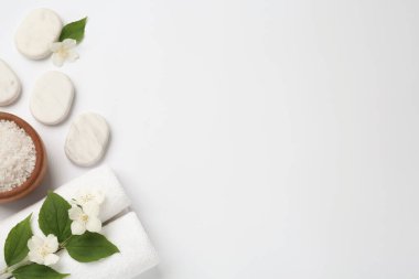 Spa taşları, yasemin çiçekleri, beyaz arka planda deniz tuzu ve havlular. Metin için boşluk