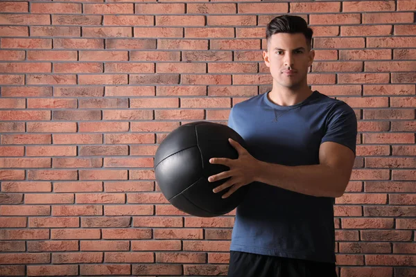 Sportlicher Mann Mit Medizinball Nahe Roter Ziegelmauer — Stockfoto