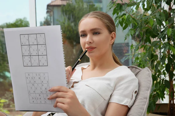 Vacker Ung Kvinna Lösa Sudoku Pussel Nära Fönstret Inomhus — Stockfoto