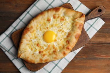Tahta masada peynirli ve yumurtalı taze ev yapımı khachapuri.