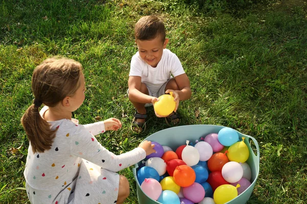 Små Barn Med Bassäng Vatten Bomber Grönt Gräs — Stockfoto