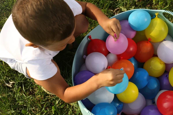 Kleiner Junge Mit Wasserbomben Auf Grünem Gras Draufsicht — Stockfoto