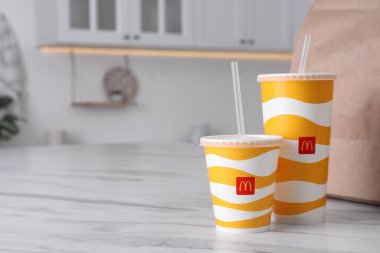 MYKOLAIV, UKRAINE - 12 Ağustos 2021: Cold McDonald 's içecekleri ve mutfakta mermer üzerine yiyecek paketlediler. Metin için boşluk