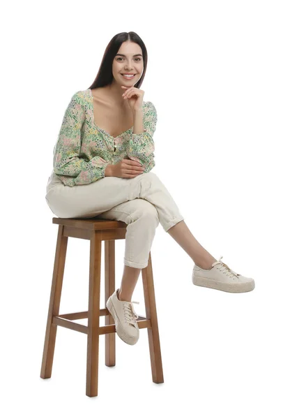 Schöne Junge Frau Sitzt Auf Einem Hocker Vor Weißem Hintergrund — Stockfoto