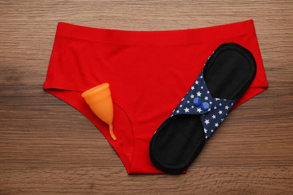Underkläder För Kvinnor Återanvändbar Tygbinda Och Menstruationskopp Träbord Ovanifrån — Stockfoto
