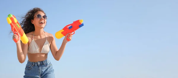 青い空に対して楽しい水銃を持つアフリカ系アメリカ人女性 — ストック写真