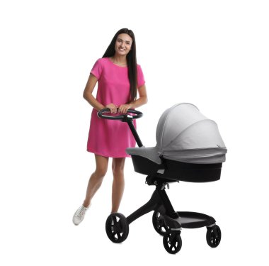 Beyaz arka planda bebek arabası olan mutlu genç bir kadın.