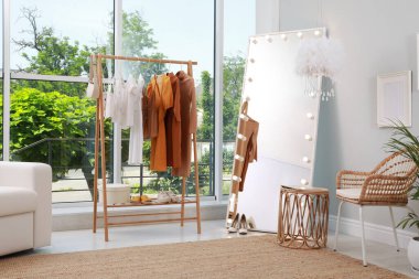 Soyunma odasında giysi askılığı ve rahat mobilyalar var.