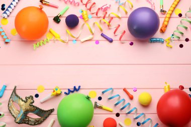 Düz kompozisyon ve pembe ahşap arka planda karnaval eşyaları. Metin için boşluk