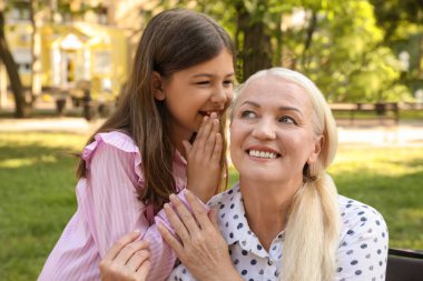 Parkta torunu olan olgun bir kadın.