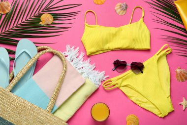 Pembe zemin üzerinde farklı plaj nesneleri ile düz kompozisyon yatıyordu