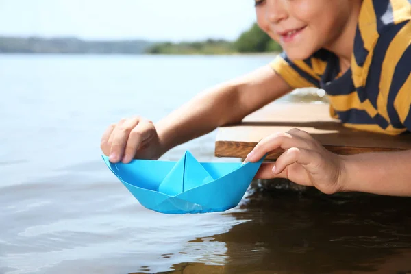 Menino Brincando Com Barco Papel Cais Perto Rio Close — Fotografia de Stock