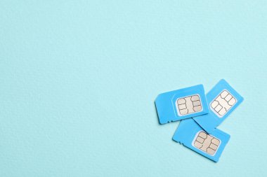 Turkuaz arka planda renkli SIM kartlar, düz konum. Metin için boşluk
