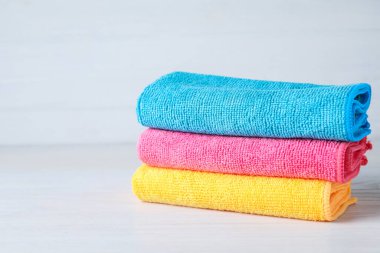 Beyaz masa üzerinde renkli mikrofiber kumaş yığını, metin için boşluk