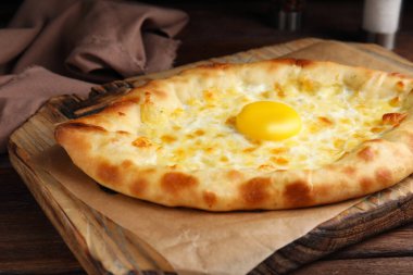 Taze ev yapımı khachapuri peynirli ve yumurtalı ahşap masa, yakın plan.