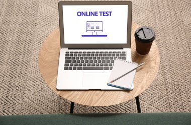İçerideki ahşap masada çevrimiçi test edilen dizüstü bilgisayar.