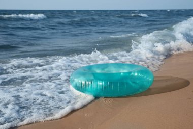 Deniz kıyısındaki kumlu kumsalda parlak şişirilebilir yüzük.