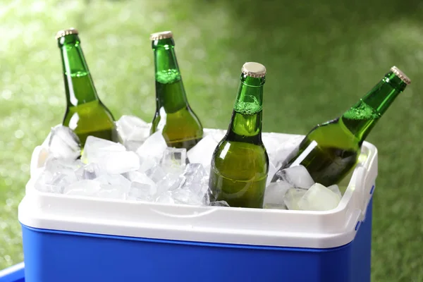 Blauwe Plastic Koelbox Met Flesjes Bier Ijsblokjes Wazig Groene Achtergrond — Stockfoto
