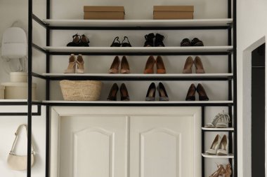 Ayakkabı ve aksesuarlar için depo rafı olan bir soyunma odası.