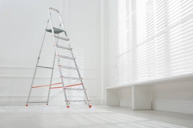 Yerde plastik kaplı metal merdiven boş bir odada, metin için yer var.