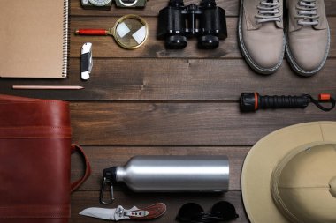 Ahşap arka planda farklı safari aksesuarları çerçevesi, düz yatış. Metin için boşluk