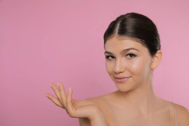 Pembe arka planda güzel bir kızın portresi, mesaj için boşluk. Güzel bir yüz, pürüzsüz bir ten.