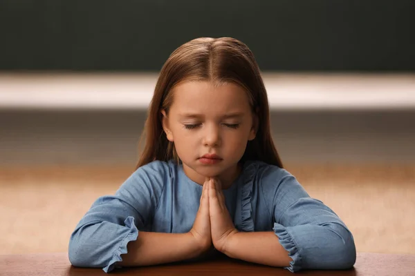 Χαριτωμένο Κοριτσάκι Χέρια Ενωμένα Προσεύχεται Στο Τραπέζι Εσωτερικούς Χώρους — Φωτογραφία Αρχείου