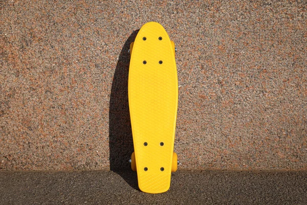 Κομψή Κίτρινη Σανίδα Skate Κοντά Εξωτερικό Τοίχο — Φωτογραφία Αρχείου